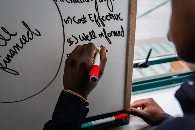 Hand writing on whiteboard with red marker, focusing on strategic planning keywords. Choosing a lead generation offer from a buyer's problem