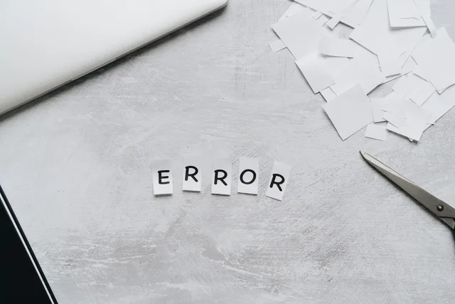Creative concept showing the word 'error' with cut out letters on a table with scissors and paper. Identifying low-quality form submissions